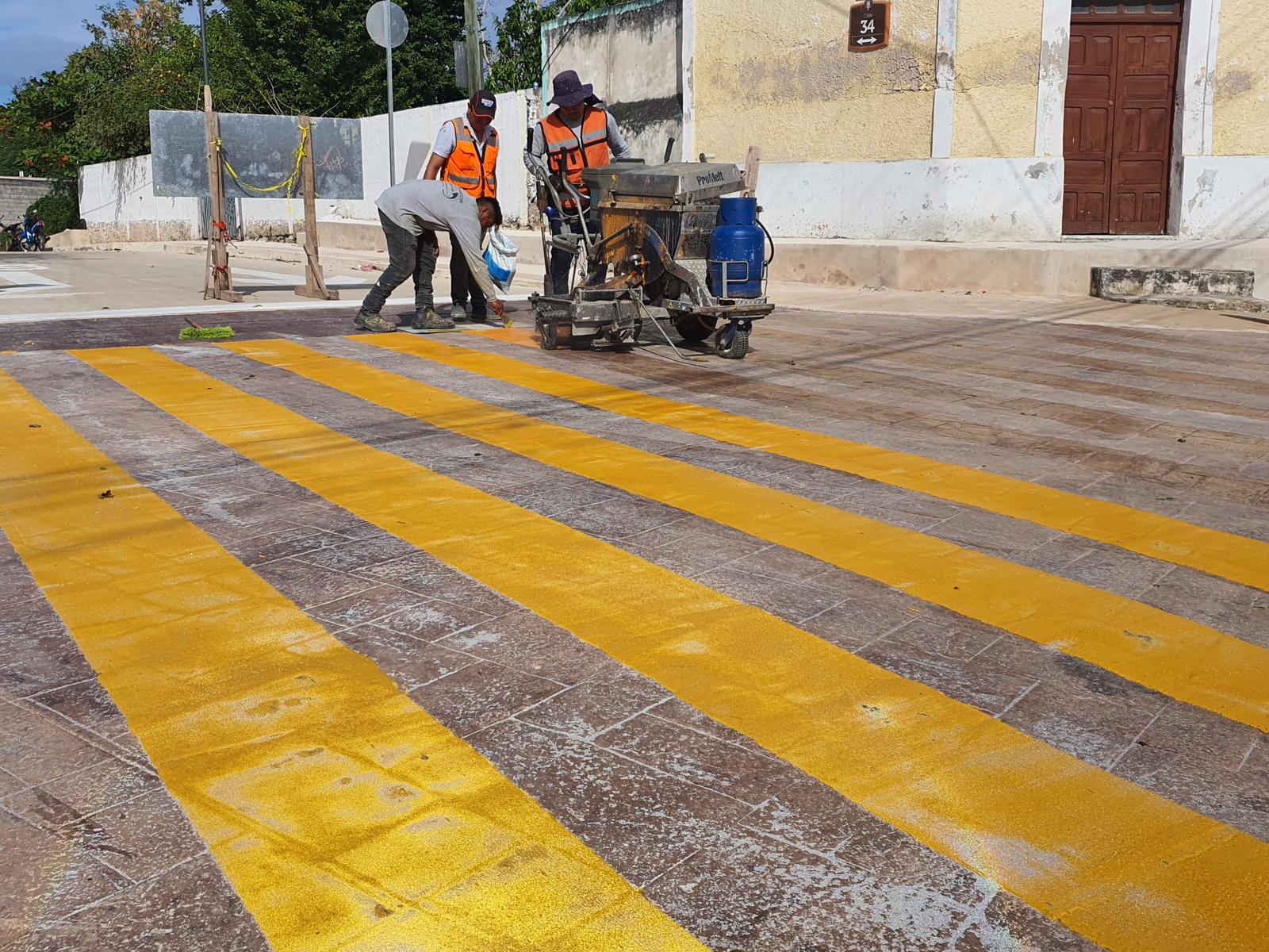 Cuadrilla aplicando un cruce peatonal con pintura termoplástica