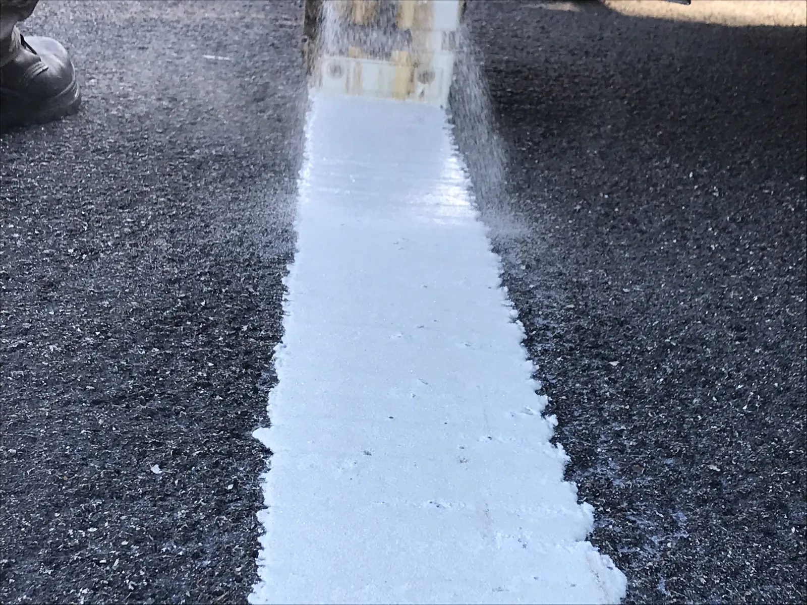 Raya blanca de termoplástica recién aplicada, todavía caliente