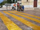 Cuadrilla aplicando un cruce peatonal con pintura termoplástica
